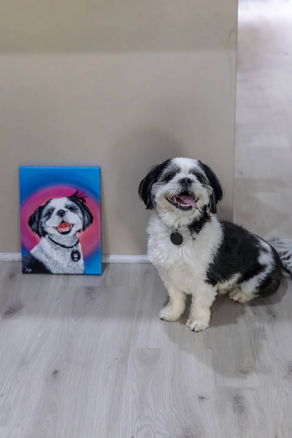 Aki the shih tzu sitting beside his finished portrait